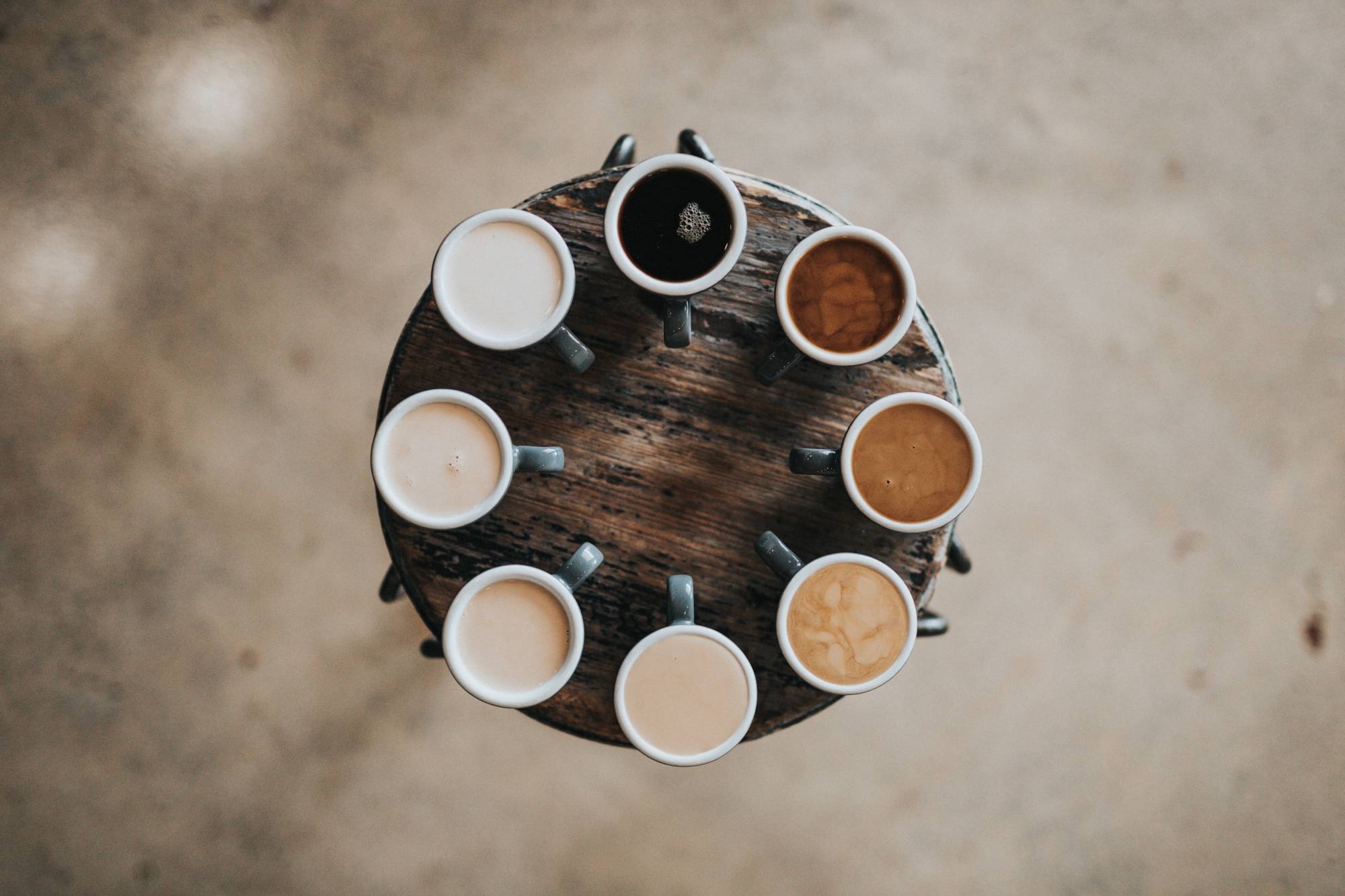 Eight different mugs of coffee beverages
