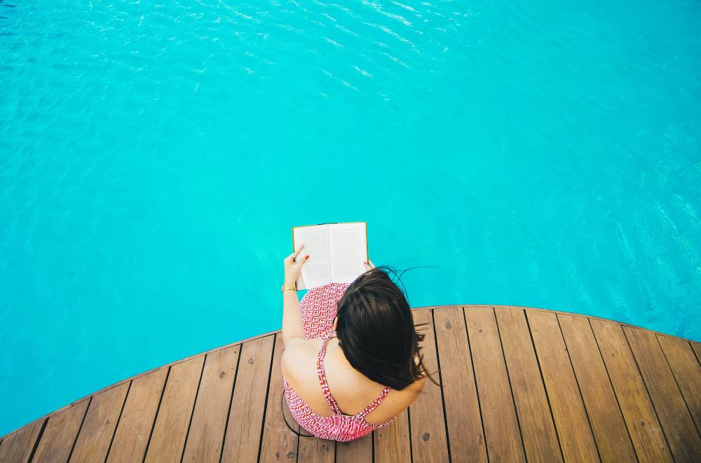 A woman reading by a pool