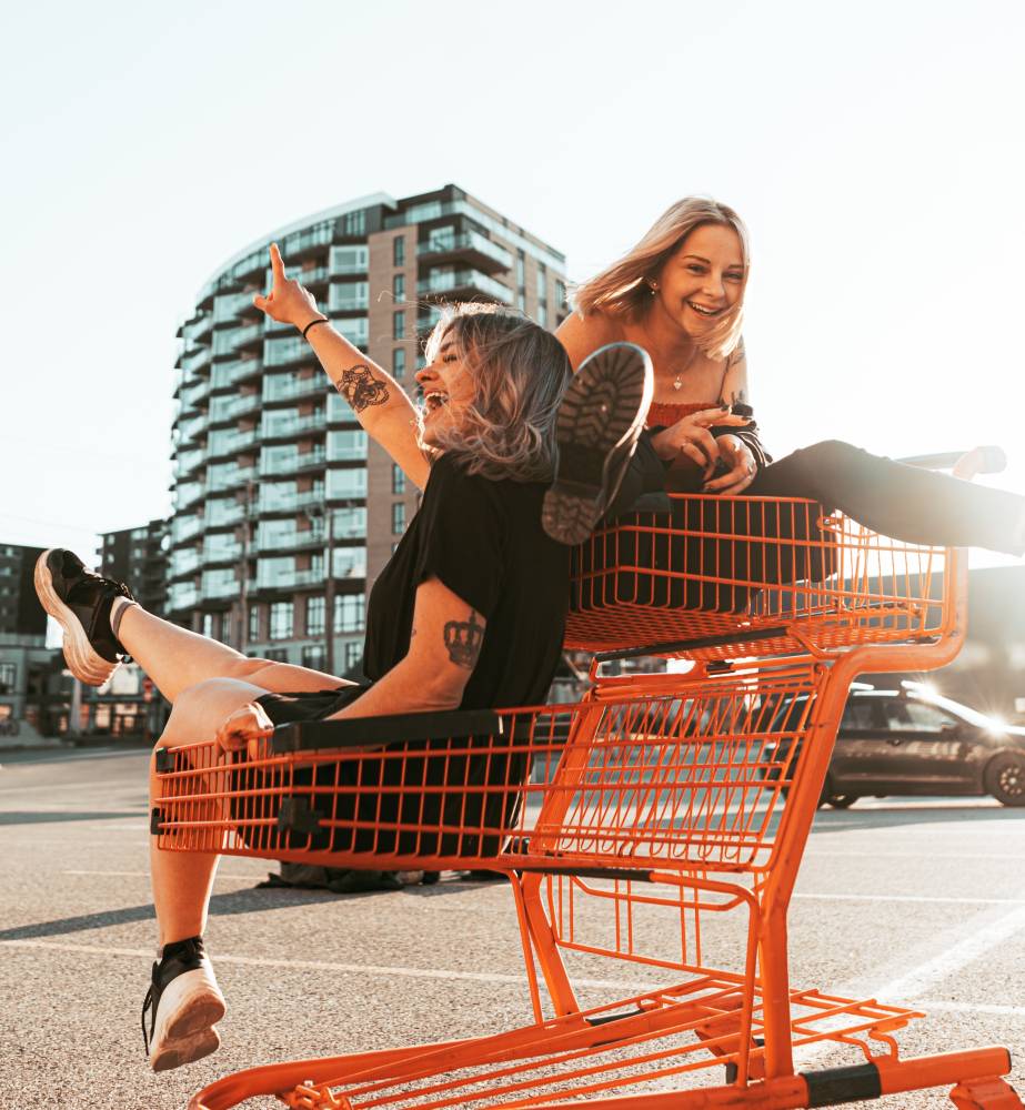 Two women playing in a red shopping cart