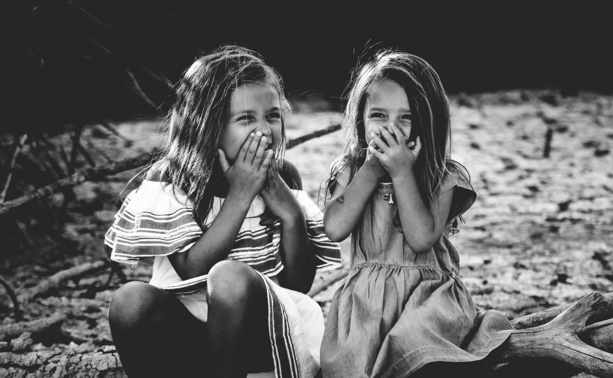 A black and white photo of two young girls laughing.