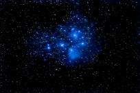A blue cluster of stars in a night sky
