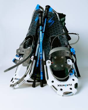 Blue, grey and silver snowshoes with white background.