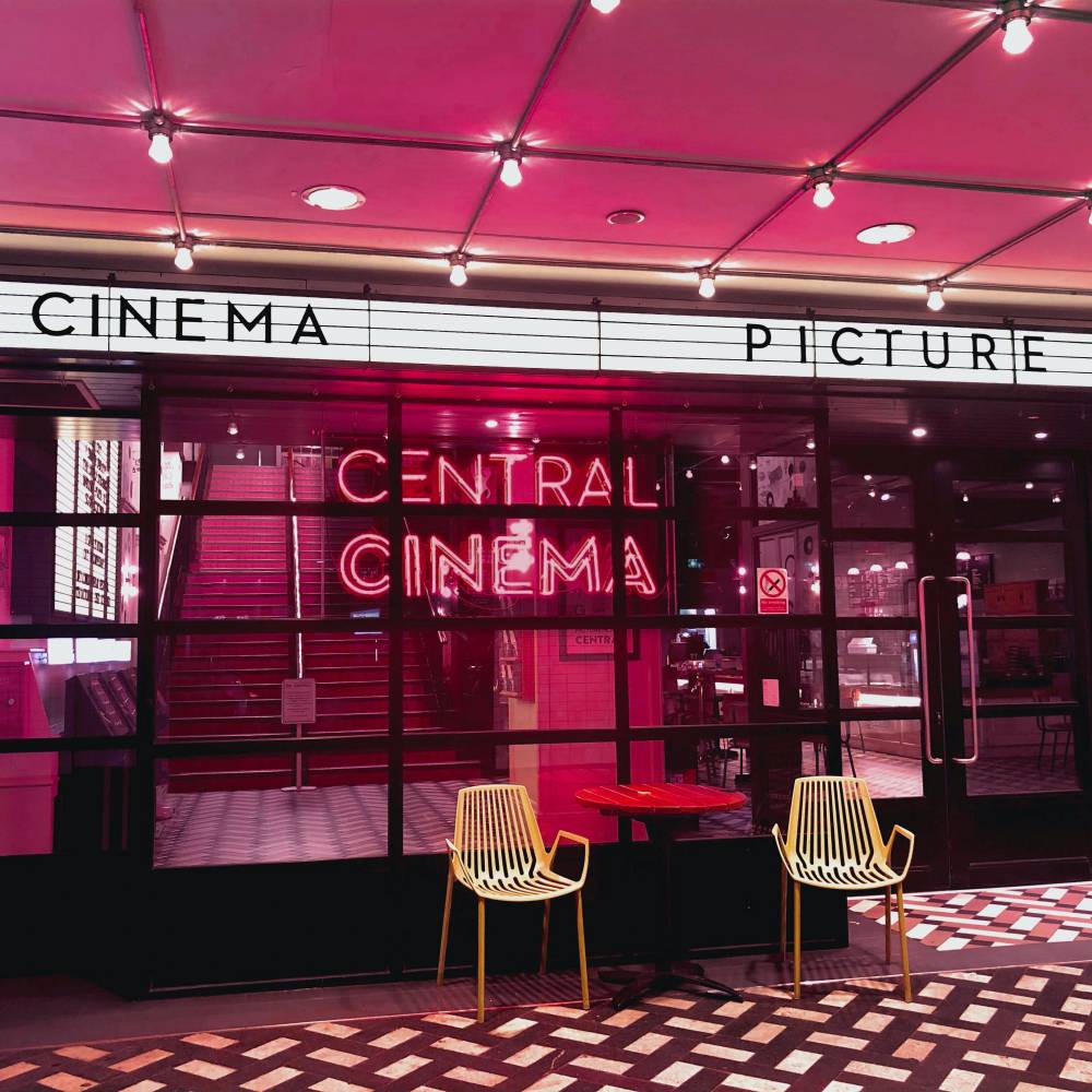 The front of a movie theater bathed in crimson light, as seen from the front doorway.