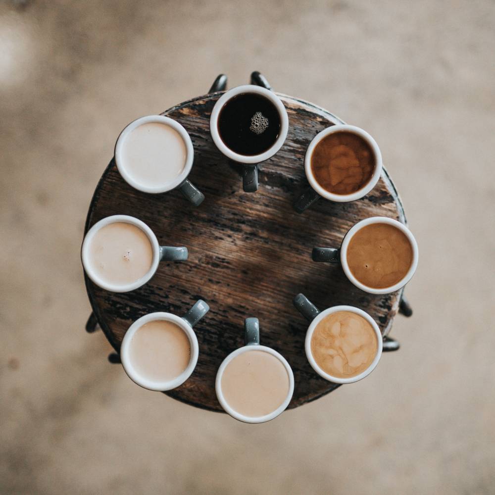 Eight different mugs of coffee beverages