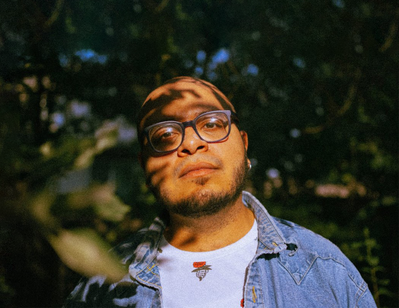 Photo of Aerik in the shade in the trees.