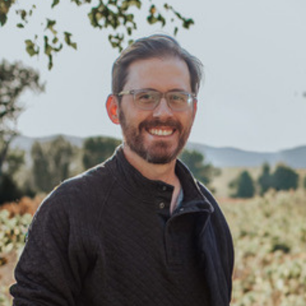 Photo of Matthew Osier outside in front of the mountains.