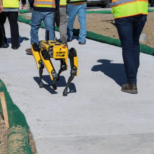CU Denver's Technology Innovation in Construction students walk alongside, Atlas, the robot dog at the Anythink Nature Library construction site.