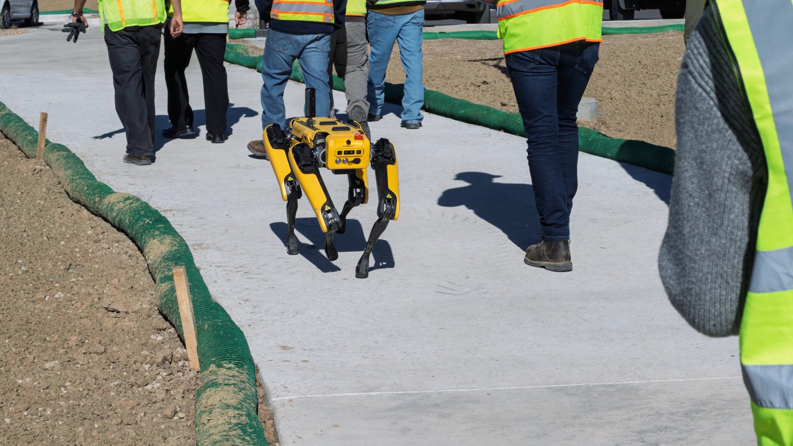 CU Denver's Technology Innovation in Construction students walk alongside, Atlas, the robot dog at the Anythink Nature Library construction site.